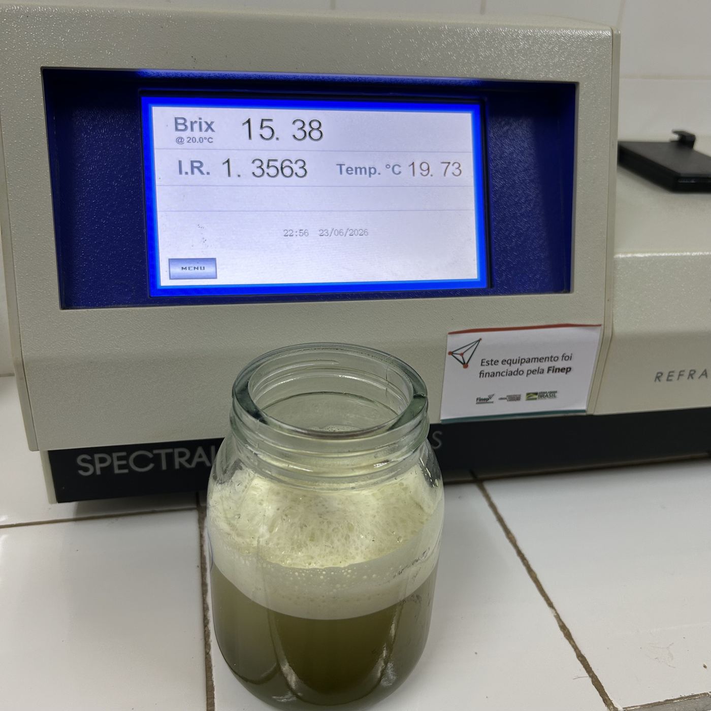 Refratômetro de bancada exibindo leitura de Brix 15,38 ao lado de amostra de caldo